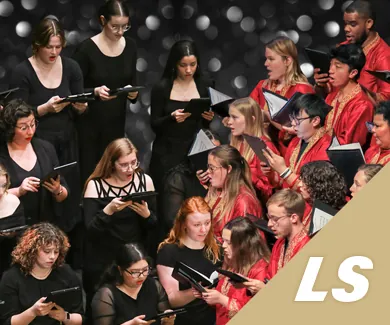 A group of young people singing on stage.