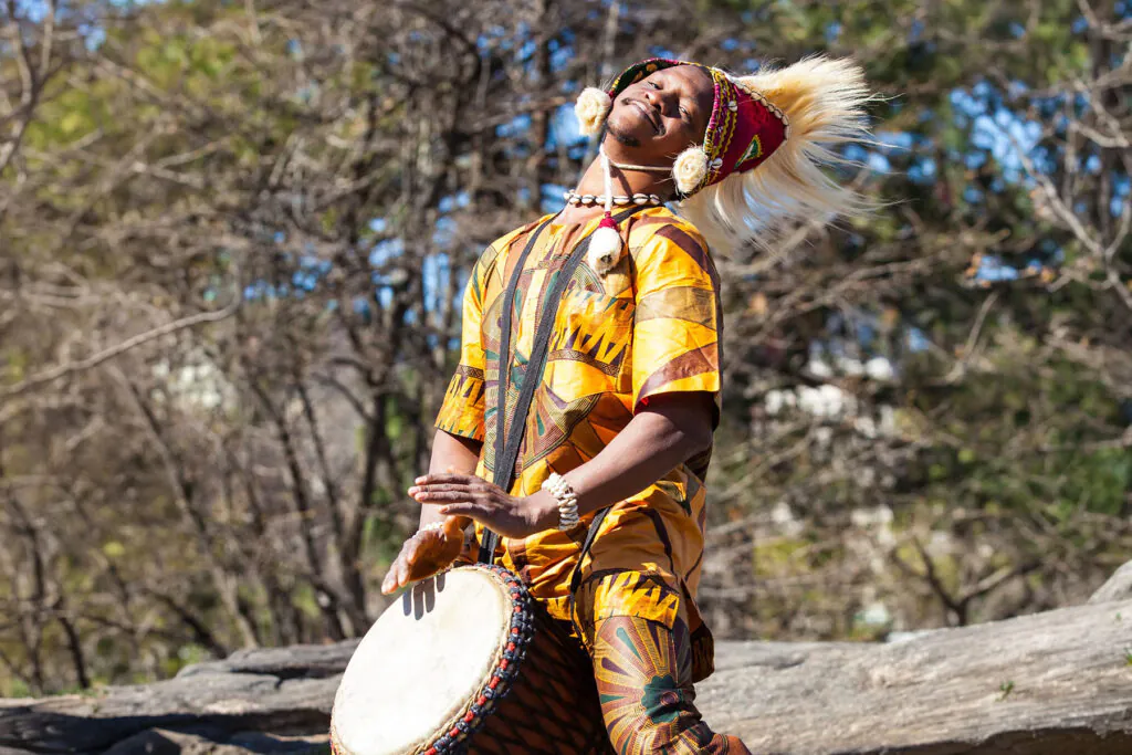 African man playing drum outside