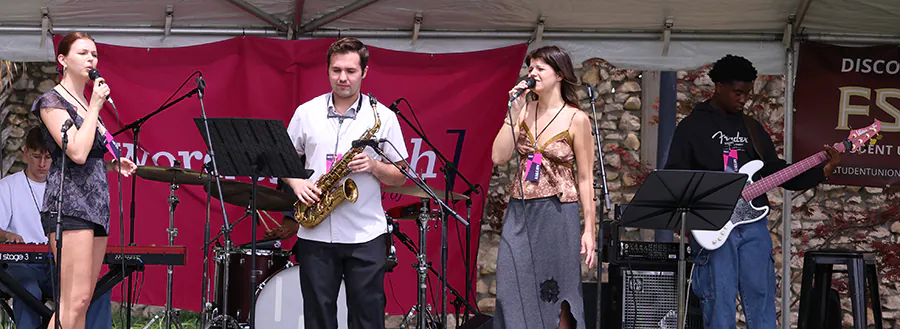 musicians on stage at an outdoor festival
