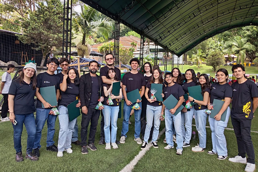 Group of young men and women in black T-shirts and blue jeans standing outside