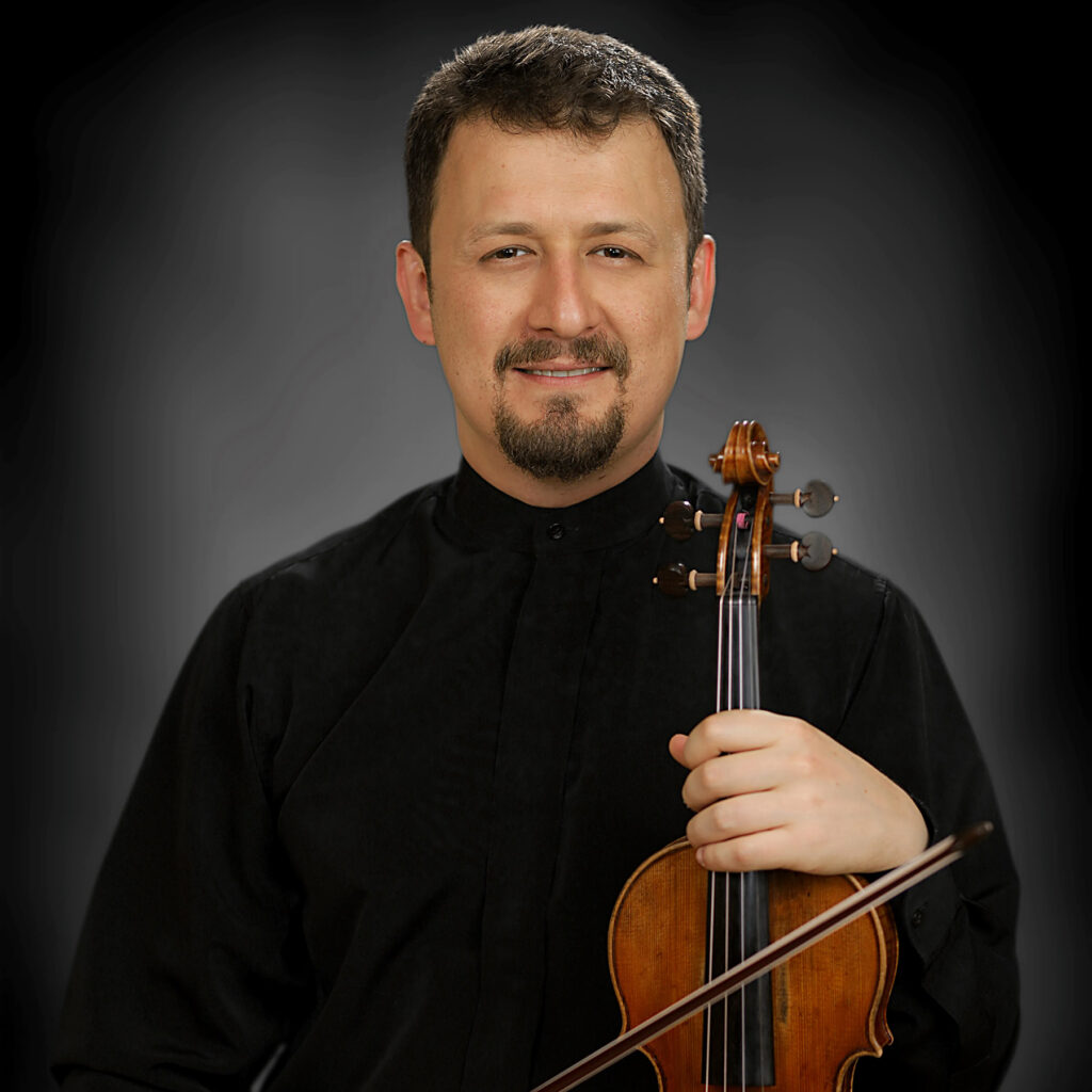 Headshot of smiling man holding violin