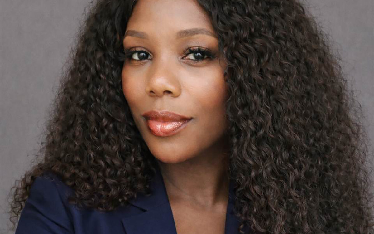 Headshot of woman with long dark hair against gray background