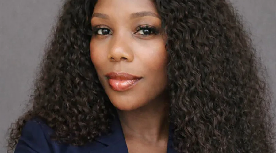 Headshot of woman with long dark hair against gray background