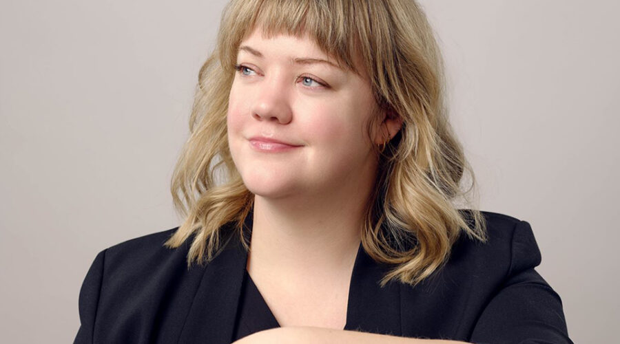 3/4 profile of smiling young woman against muted backdrop