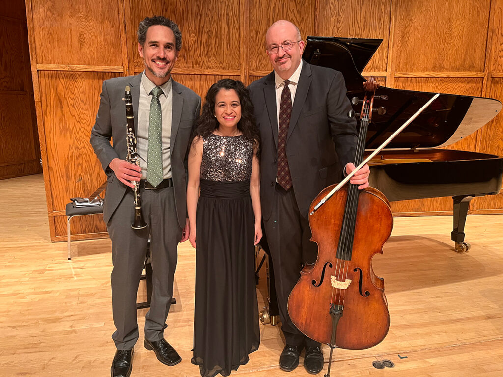musicians standing on stage holding instruments