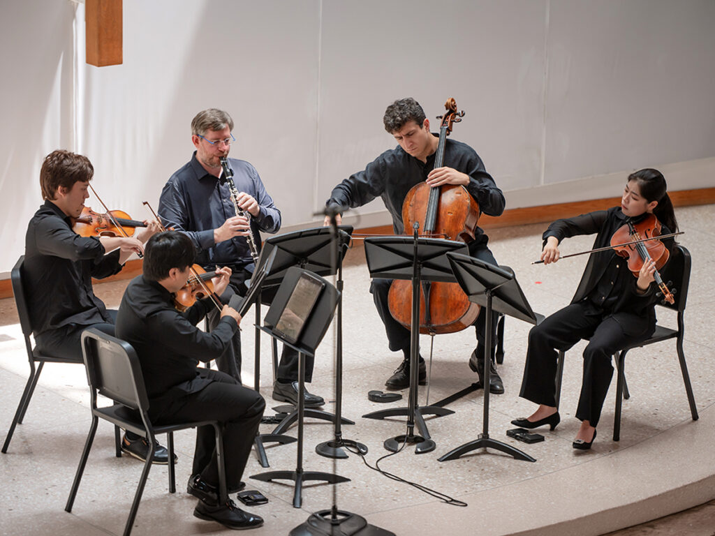 Young men and women playing instruments on stage