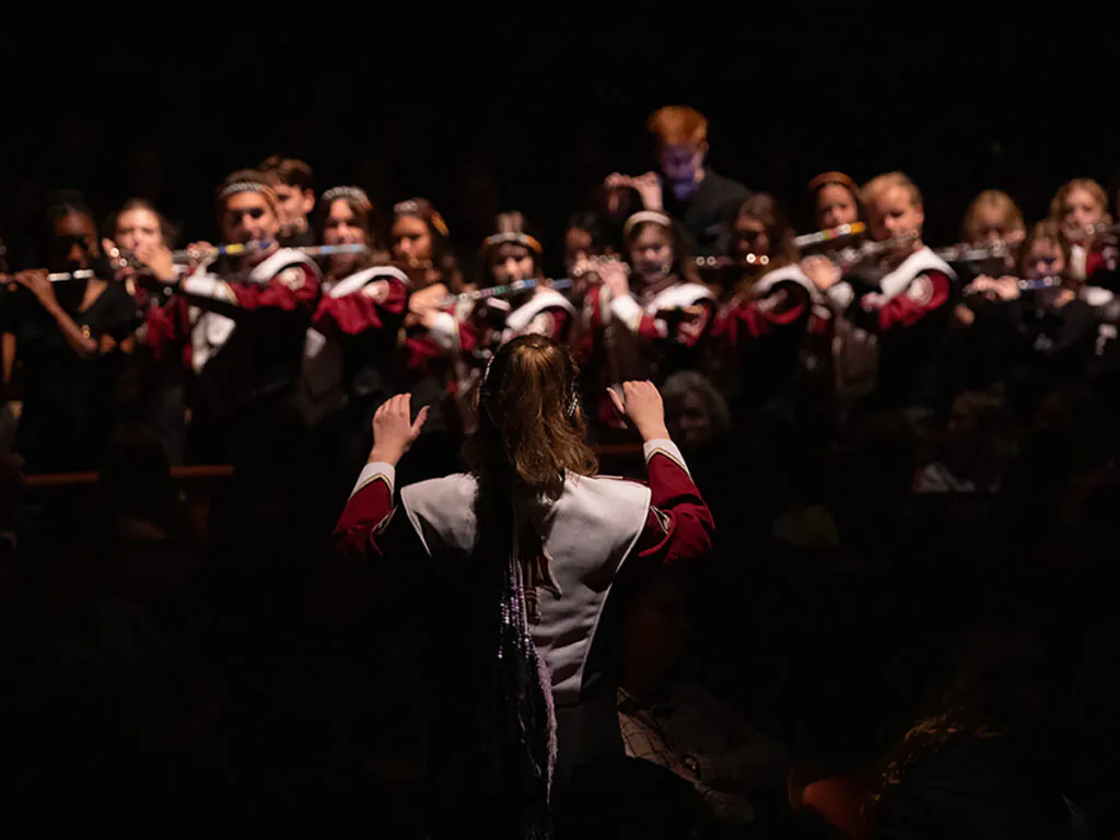 Drum major conducting flute section of marching band
