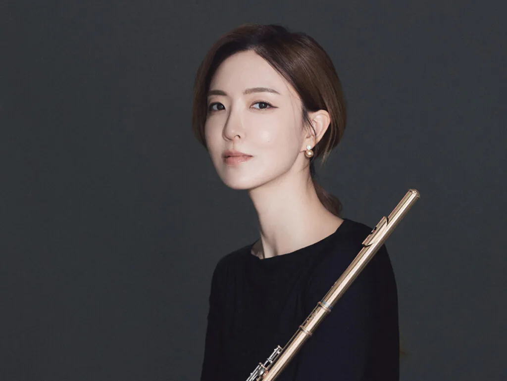 Closeup of young woman holding flute