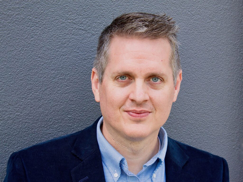 Closeup headshot of man in blue suit