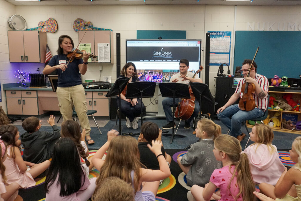String musicians talk and perform for a classroom of elementary school children