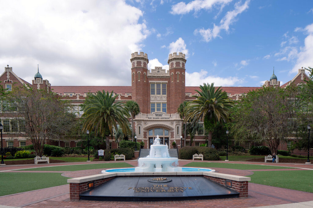 Decorative fountain in front of large brick building (Westcott Building)
