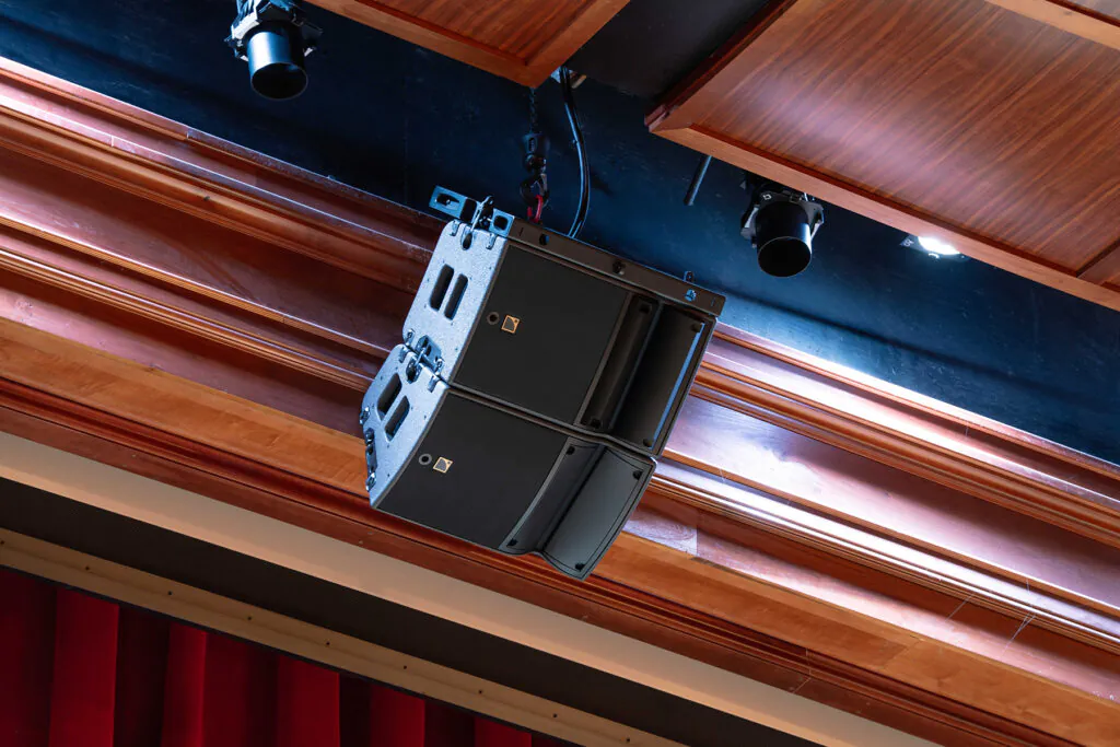 closeup of a pair of speakers mounted above a stage