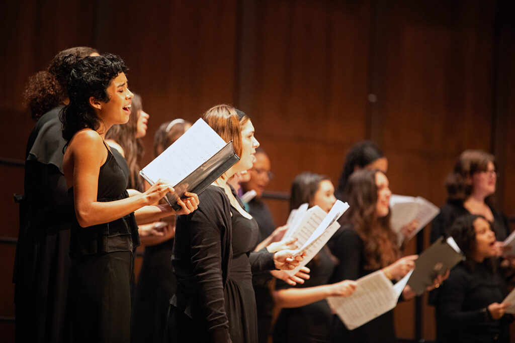 Young choral student singing passionately on stage during performance