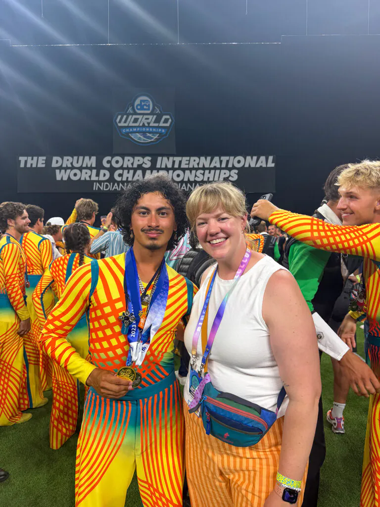 Young man with medals posing with smiling young woman