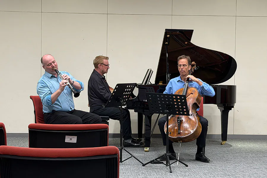 Cellist, clarinetist, and pianist in performance