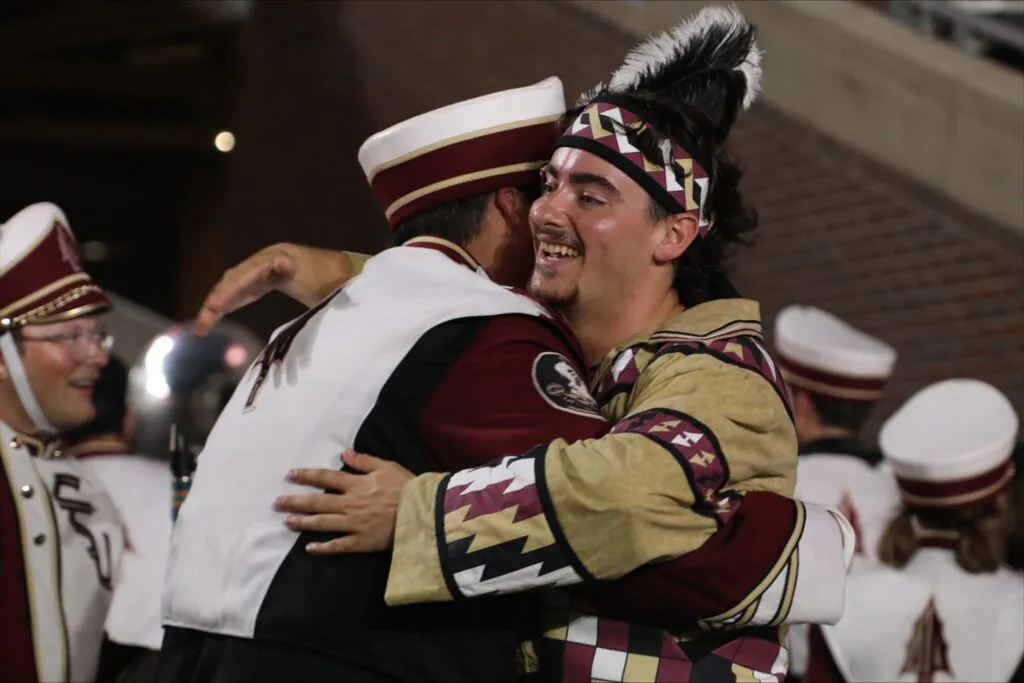 Band members hugging on field